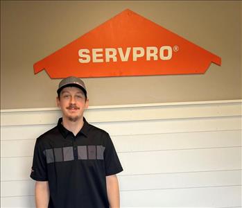 Young man standing in front of the SERVPRO sign.