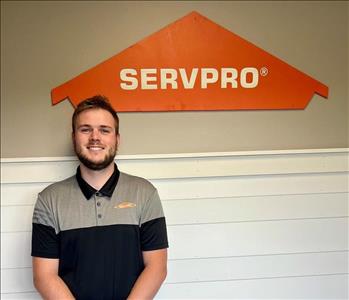 Young man standing in front of the SERVPRO sign.